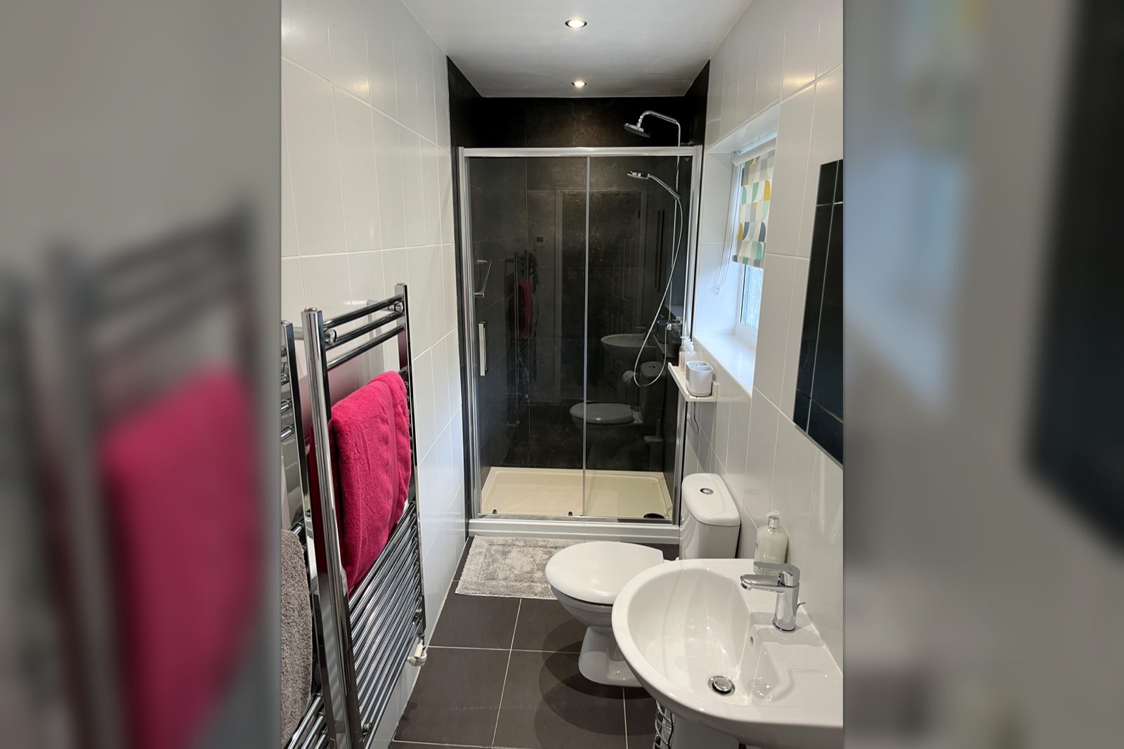 En-suite bathroom at The Bungalow Burnley with electric shower, sink, toilet and heated towel rail