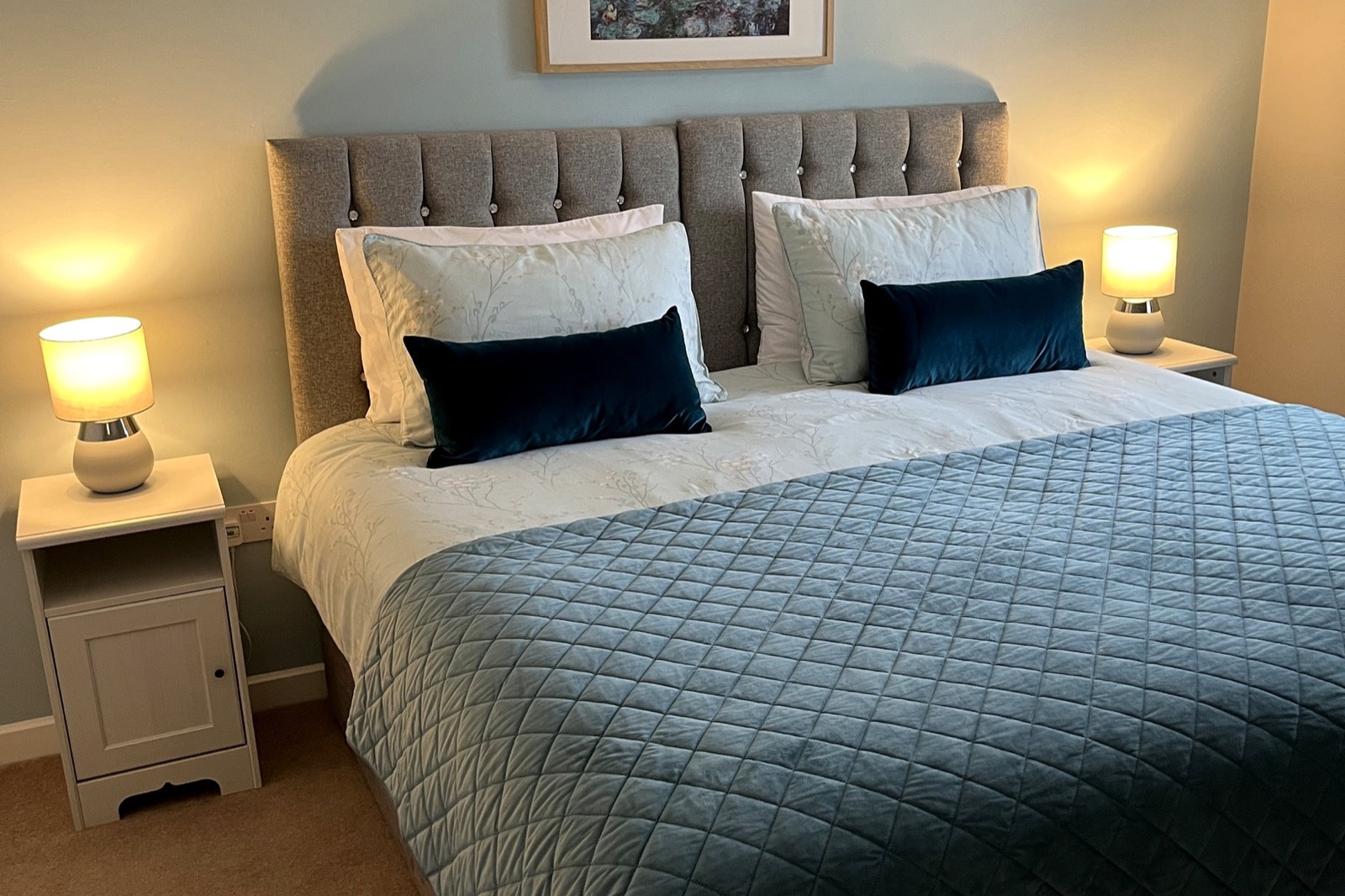 Bedroom at The Bungalow Burnley with blue bedding and bedside lamps